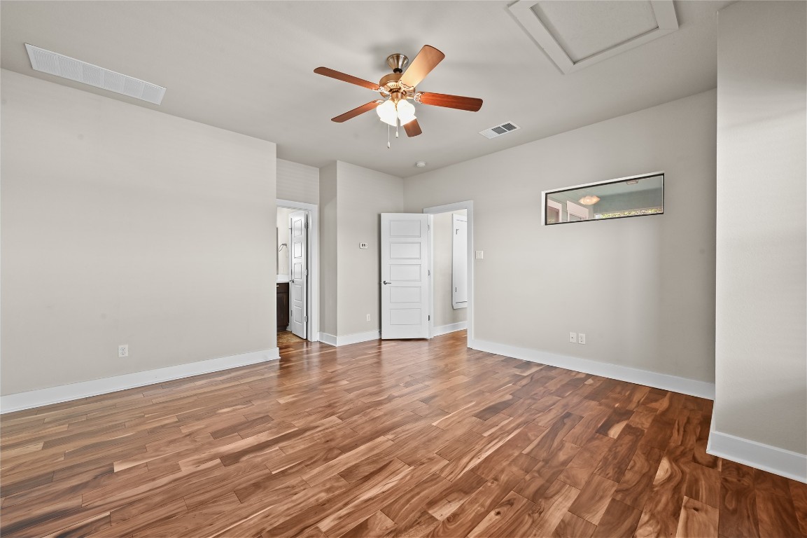 1504 Lorraine Loop, Unit B Austin, TX 78758 - Photo 17 of 25 an empty room with wooden floor and ceiling fan