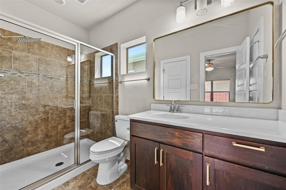 1504 Lorraine Loop, Unit B Austin, TX 78758 - Photo 18 of 25 a bathroom with a granite countertop sink toilet a mirror and shower