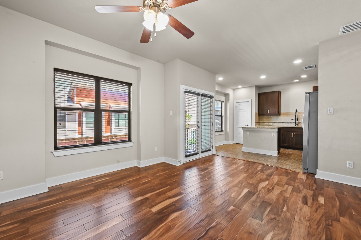 1504 Lorraine Loop, Unit B Austin, TX 78758 - Photo 5 of 25 a view of an empty room with wooden floor and a kitchen