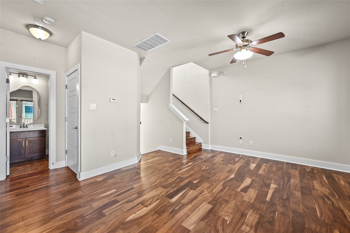 1504 Lorraine Loop, Unit B Austin, TX 78758 - Photo 8 of 25 a view of an empty room with wooden floor and a ceiling fan