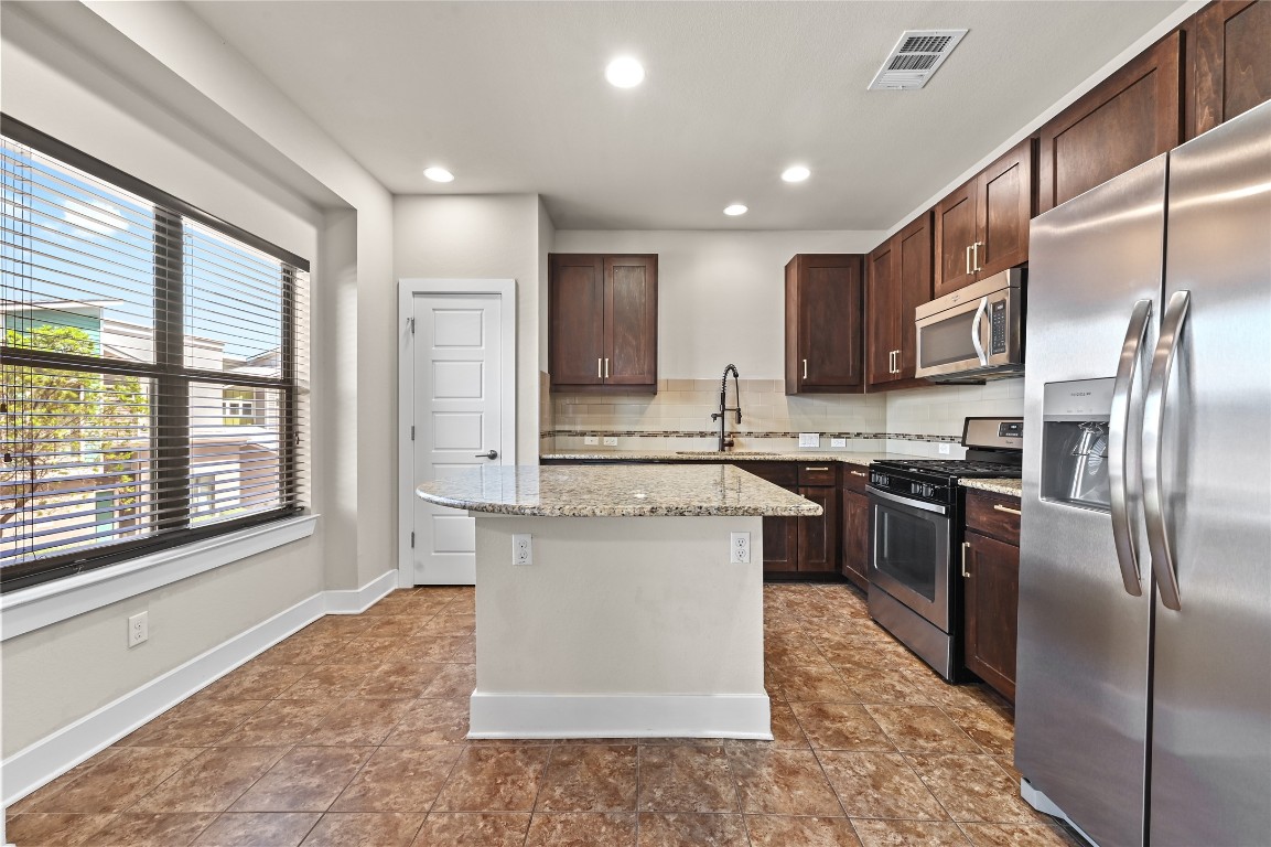 1504 Lorraine Loop, Unit B Austin, TX 78758 - Photo 9 of 25 a kitchen with stainless steel appliances granite countertop a refrigerator a sink a stove and oven