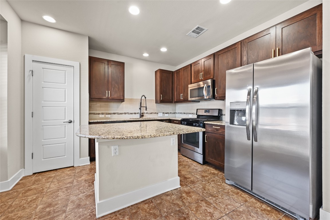1504 Lorraine Loop, Unit B Austin, TX 78758 - Photo 10 of 25 a kitchen with kitchen island stainless steel appliances cabinets a sink and a counter top space