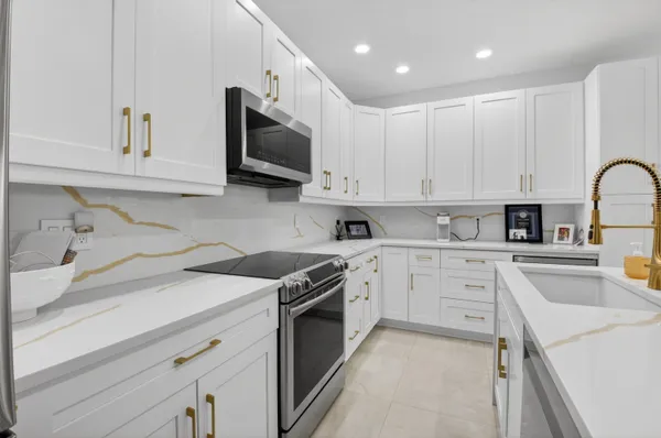 a kitchen with sink stove top oven and microwave