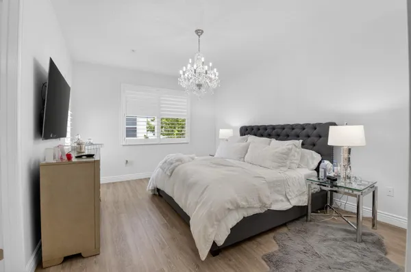 a bedroom with a bed and a flat tv screen on dresser