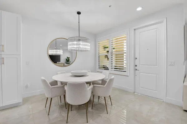 a kitchen with a dining table chairs appliances and cabinets