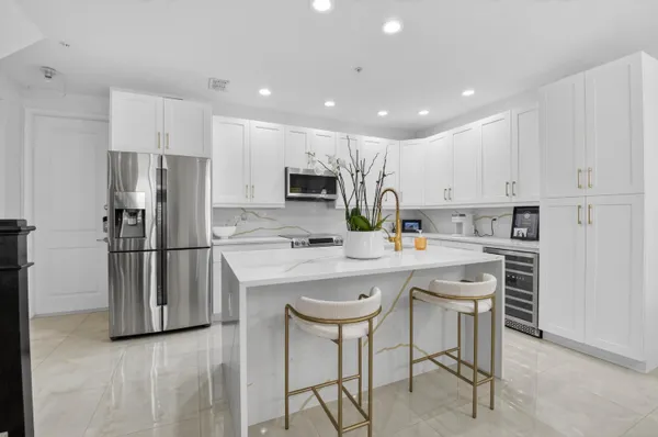 a kitchen with white cabinets and stainless steel appliances