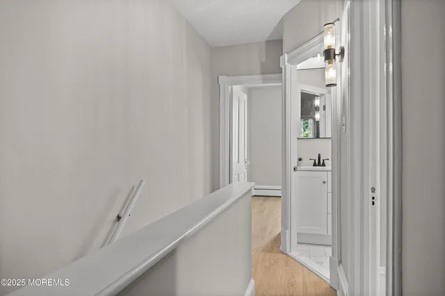 a view of a hallway with white walls and stairs