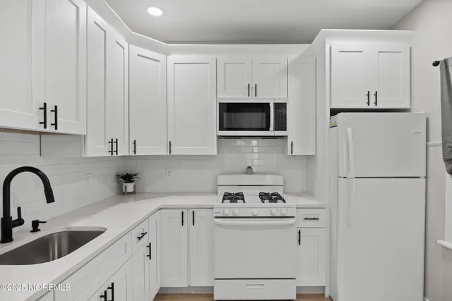 a kitchen with appliances a sink and cabinets
