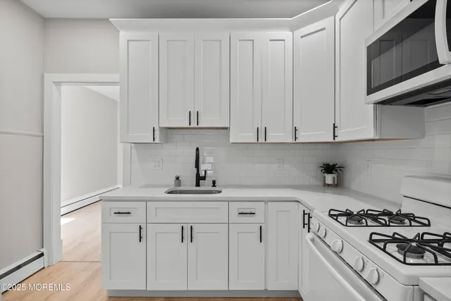 a kitchen with white cabinets and appliances
