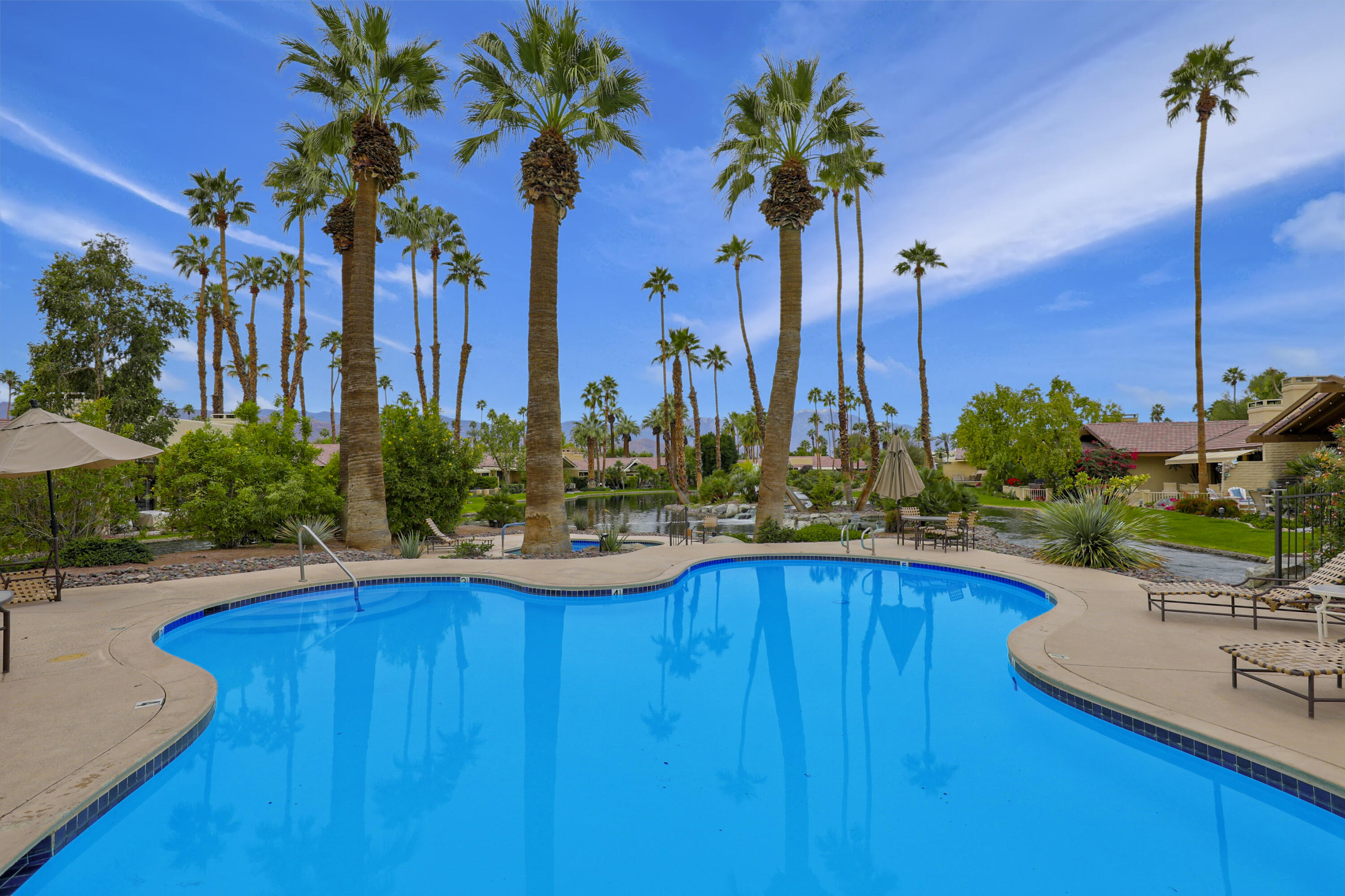 148 Deer Spring Way Palm Desert, CA 92211 - Photo 28 of 54 a view of a swimming pool with a table and chairs