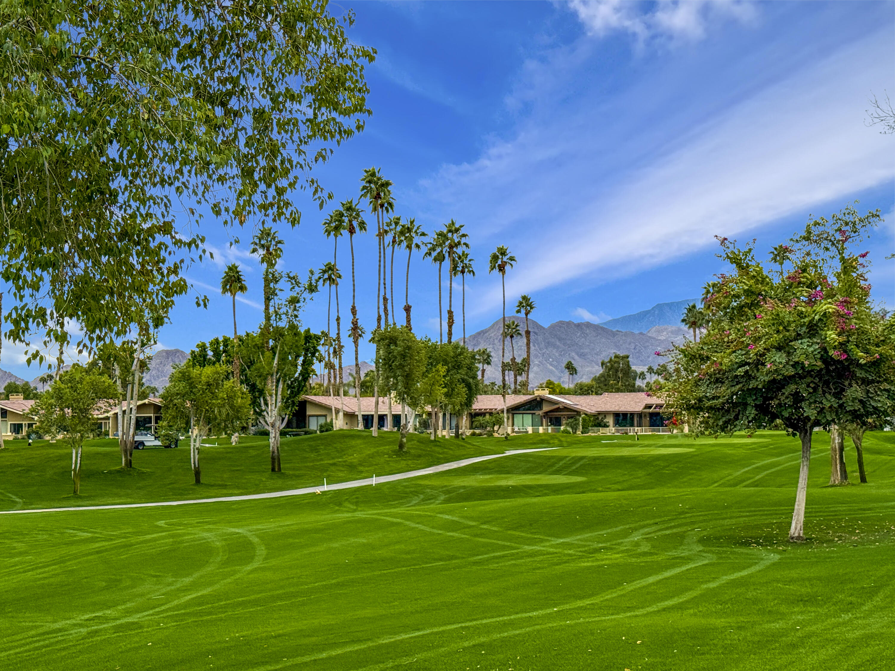 148 Deer Spring Way Palm Desert, CA 92211 - Photo 31 of 54 a view of a golf course with a house in the background