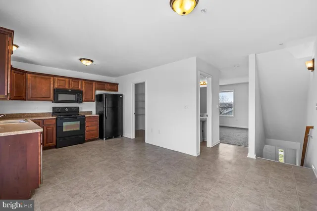 a open kitchen with stainless steel appliances granite countertop a refrigerator and stove top oven