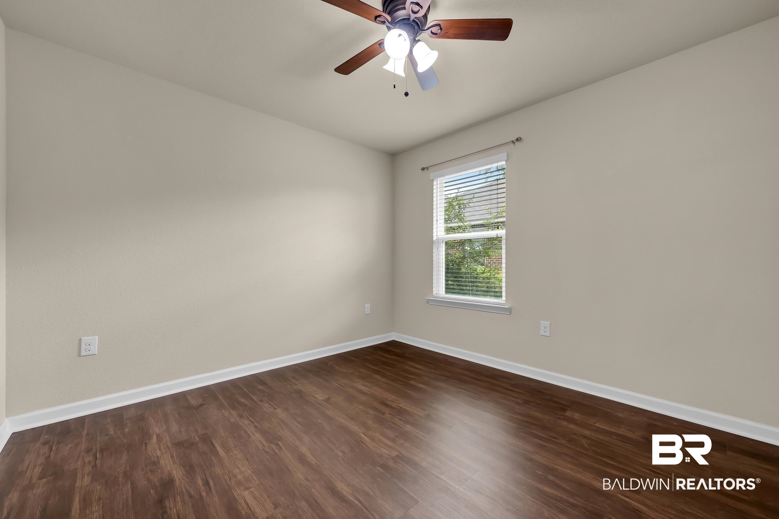 1704 Abbey Loop Foley, AL 36535 - Photo 26 of 38 Neutral tone walls complement the dark wood-finish flooring