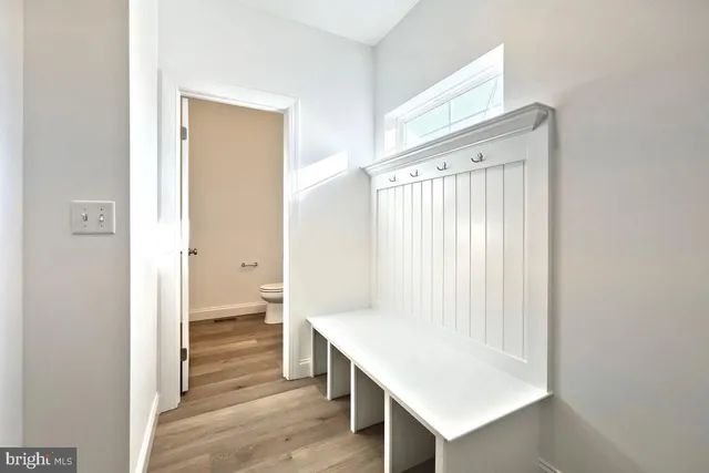 a view of a hallway with wooden floor and cabinet