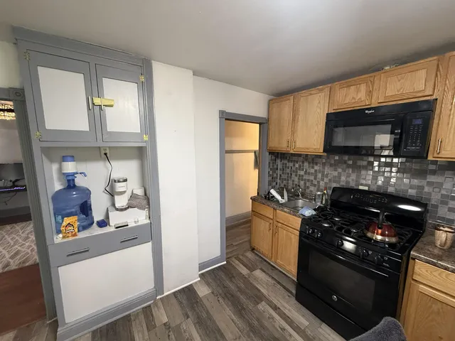 a kitchen with stainless steel appliances granite countertop a stove microwave and sink
