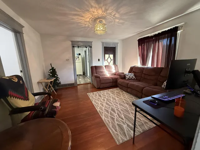 a living room with furniture a flat screen tv and a window