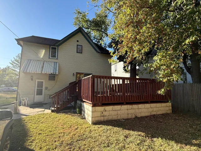 a view of a house with a large window and wooden fence