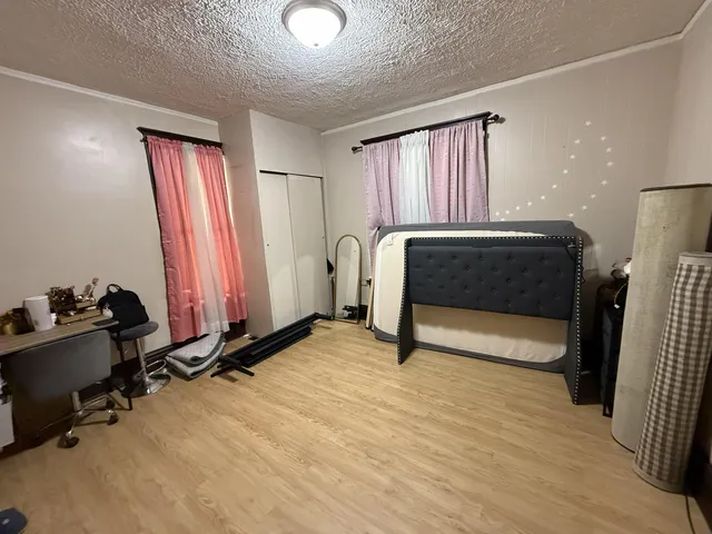 a bedroom with a bed and wooden floor