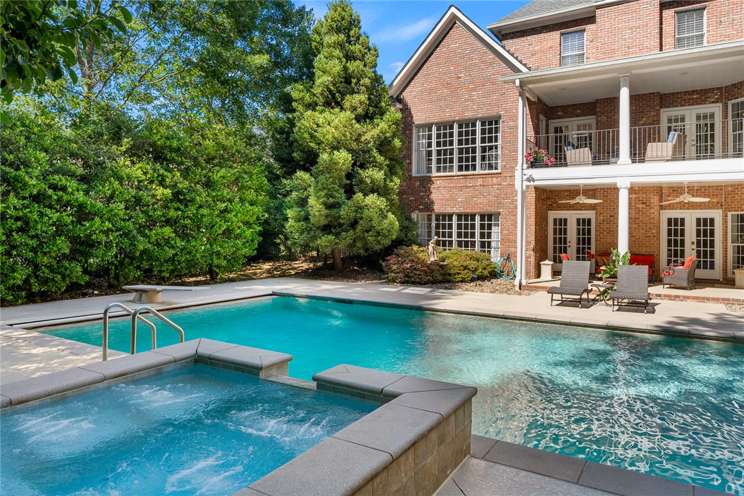 200 Graylyn Drive Anderson, SC 29621 - Photo 42 of 48 A spacious backyard oasis features an inviting inground pool and spa, complementing the brick exterior and private balcony.