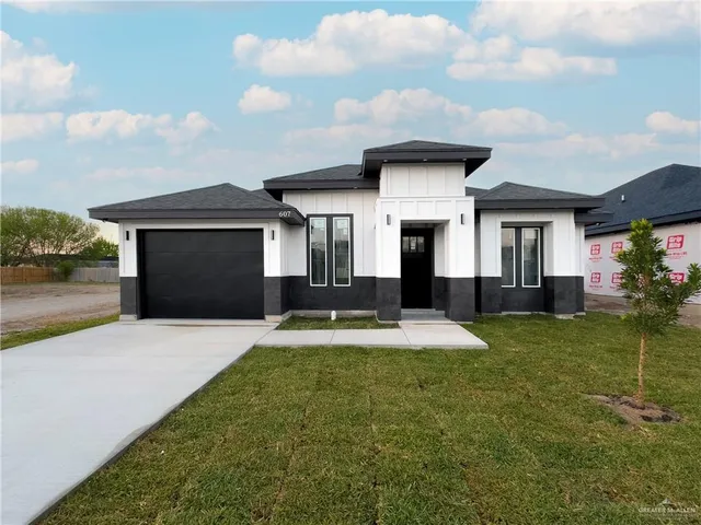 a front view of a house with a yard and garage