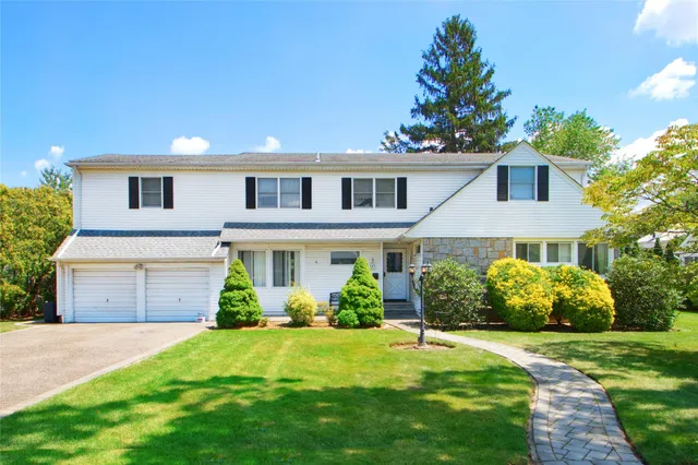 a front view of a house with a garden and plants