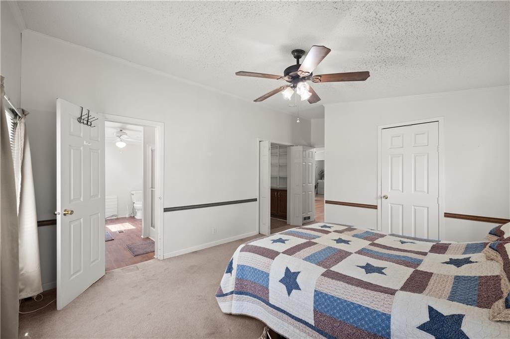 1000 Jim Johnson Road Northwest Winder, GA 30680 - Photo 14 of 37 a bedroom with a bed and a chandelier