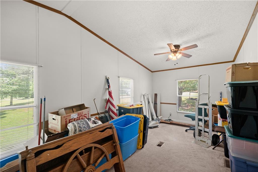 1000 Jim Johnson Road Northwest Winder, GA 30680 - Photo 21 of 37 a living room with furniture a flat screen tv and a floor to ceiling window