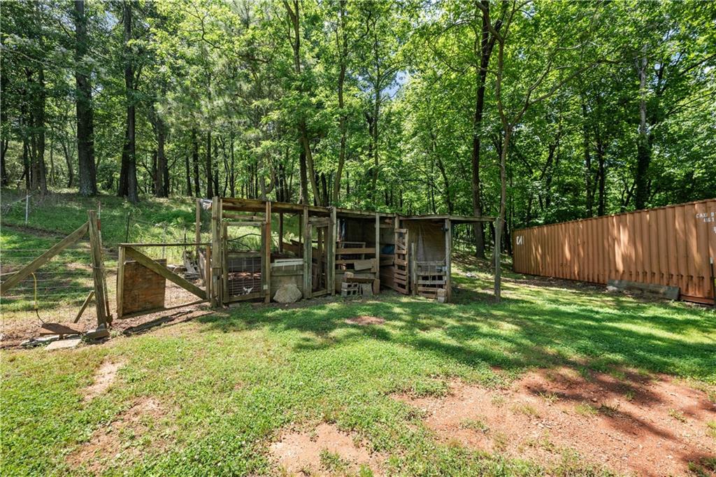 1000 Jim Johnson Road Northwest Winder, GA 30680 - Photo 28 of 37 a view of a backyard with a small cabin and a chair
