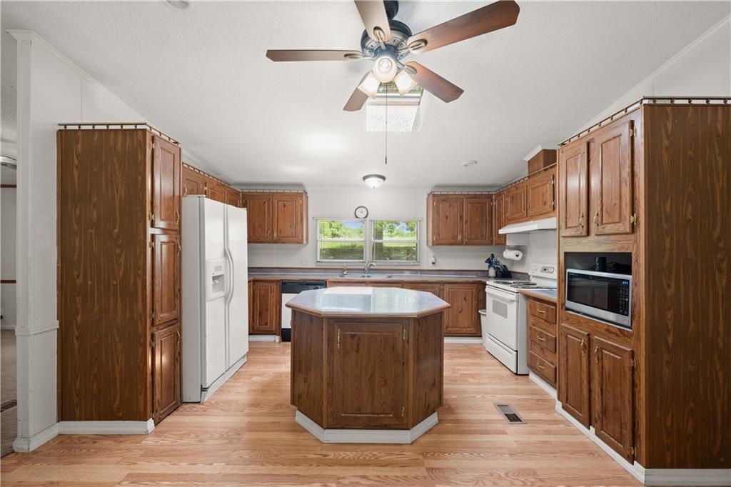 1000 Jim Johnson Road Northwest Winder, GA 30680 - Photo 9 of 37 a kitchen with stainless steel appliances granite countertop a refrigerator a stove a sink and a refrigerator