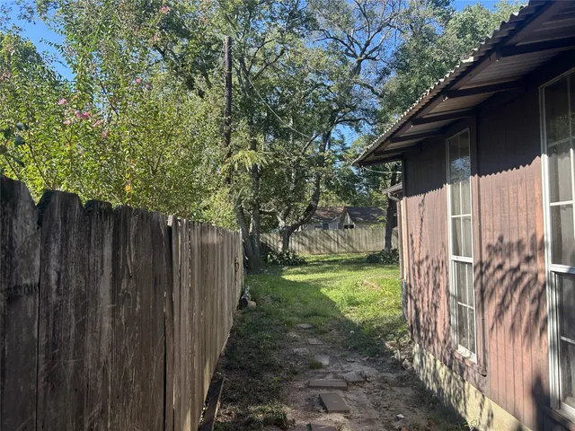 a view of a yard with wooden fence