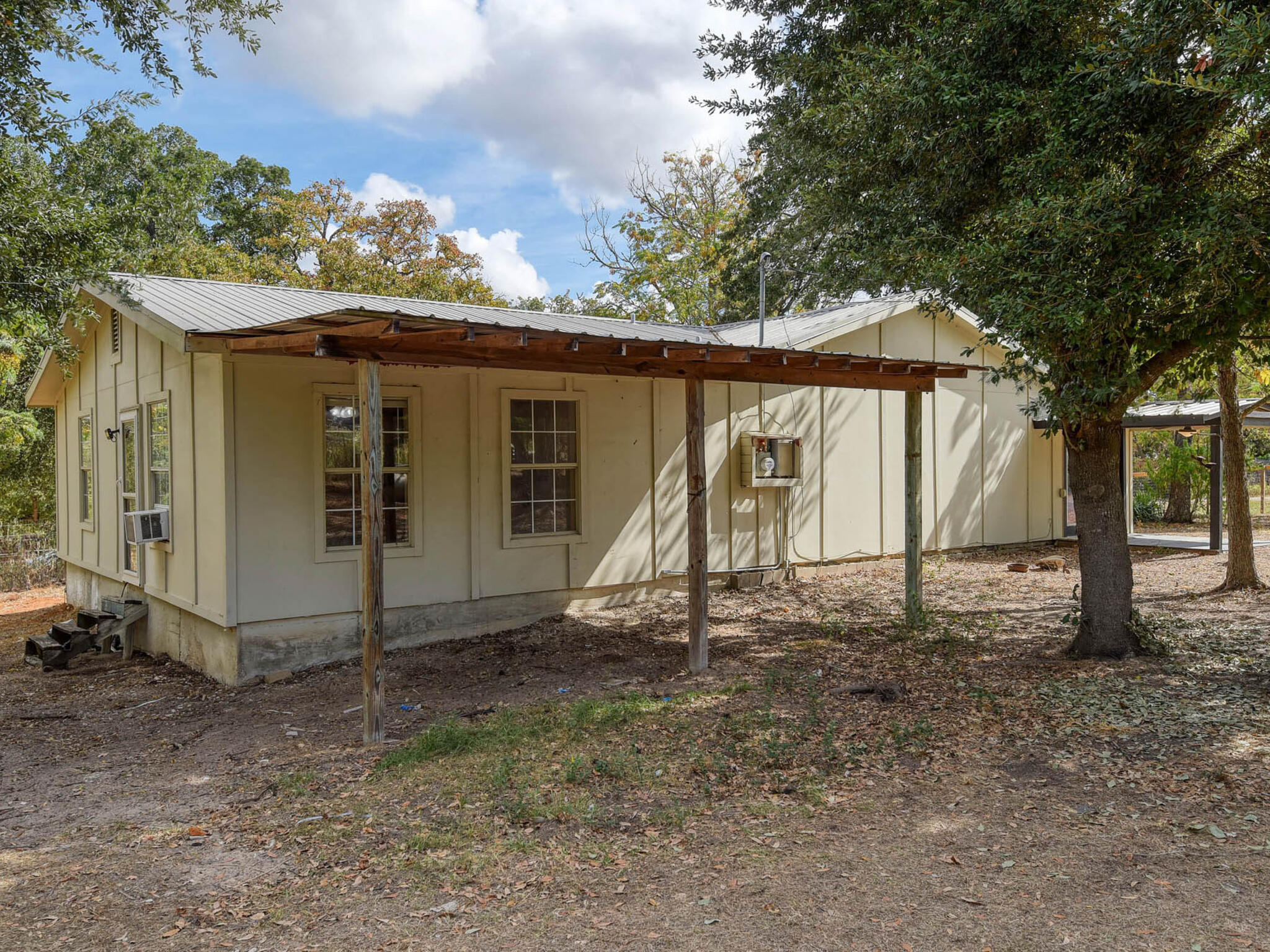 176 Lacy Drive Elgin, TX 78621 - Photo 28 of 40 a view of a barn in the backyard with large tree and wooden fence