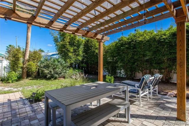 a view of a patio with table and chairs with wooden floor and fence