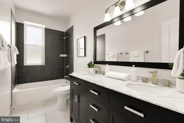 a bathroom with a granite countertop sink a large mirror a bathtub and a shower