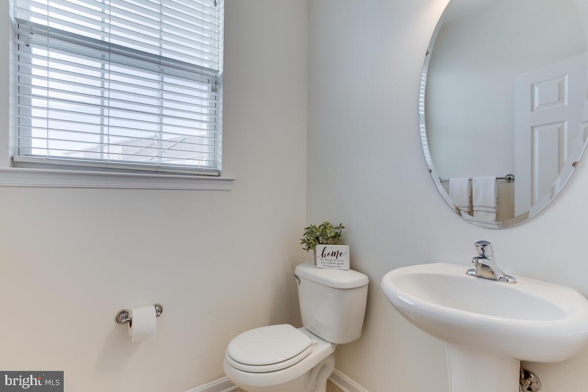102 Backstretch Way Prince Frederick, MD 20678 - Photo 19 of 44 a bathroom with a sink a mirror a toilet and a window