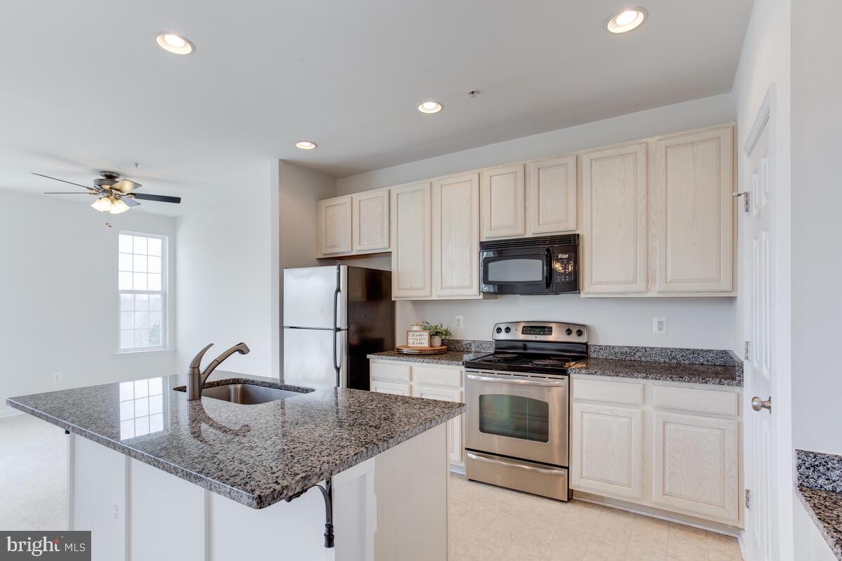 102 Backstretch Way Prince Frederick, MD 20678 - Photo 6 of 44 a kitchen with granite countertop a sink stainless steel appliances and white cabinets