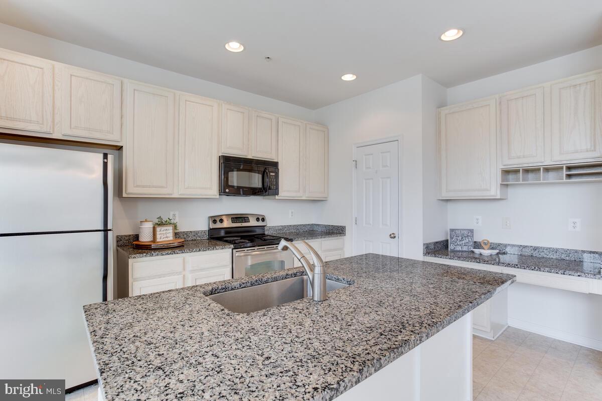 102 Backstretch Way Prince Frederick, MD 20678 - Photo 7 of 44 a kitchen with granite countertop a sink stove and refrigerator