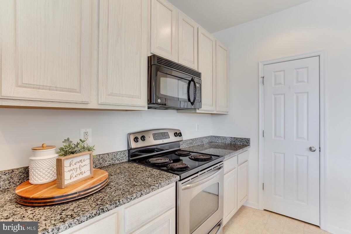 102 Backstretch Way Prince Frederick, MD 20678 - Photo 8 of 44 a kitchen with stainless steel appliances granite countertop a stove a microwave and cabinets