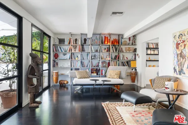 a living room with furniture and a book shelf