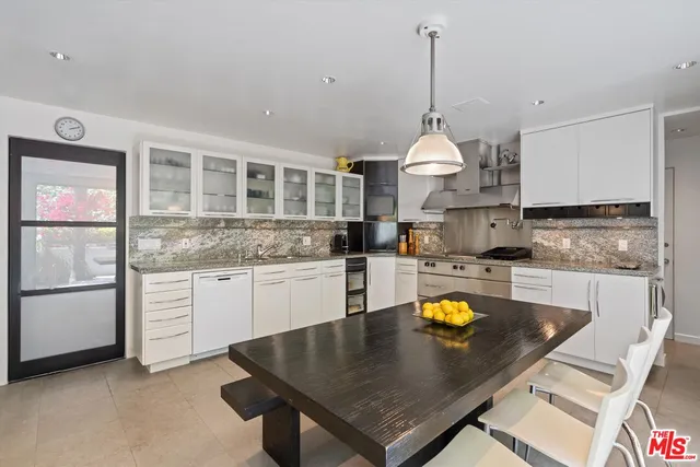 a kitchen with stainless steel appliances granite countertop a stove refrigerator and cabinets