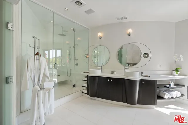 a spacious bathroom with a double vanity sink mirror and bathtub