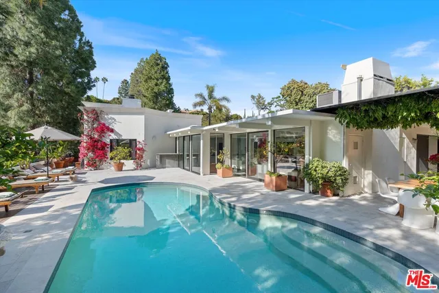a view of a house with swimming pool and sitting area