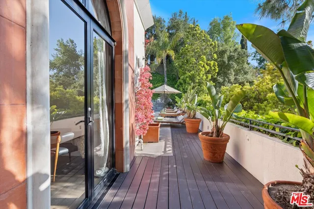 a view of a balcony with chair and potted plants