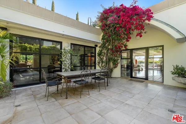 a view of a patio with a table and chairs and potted plants