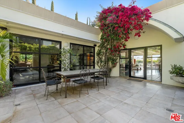 a view of a patio with a table and chairs and potted plants