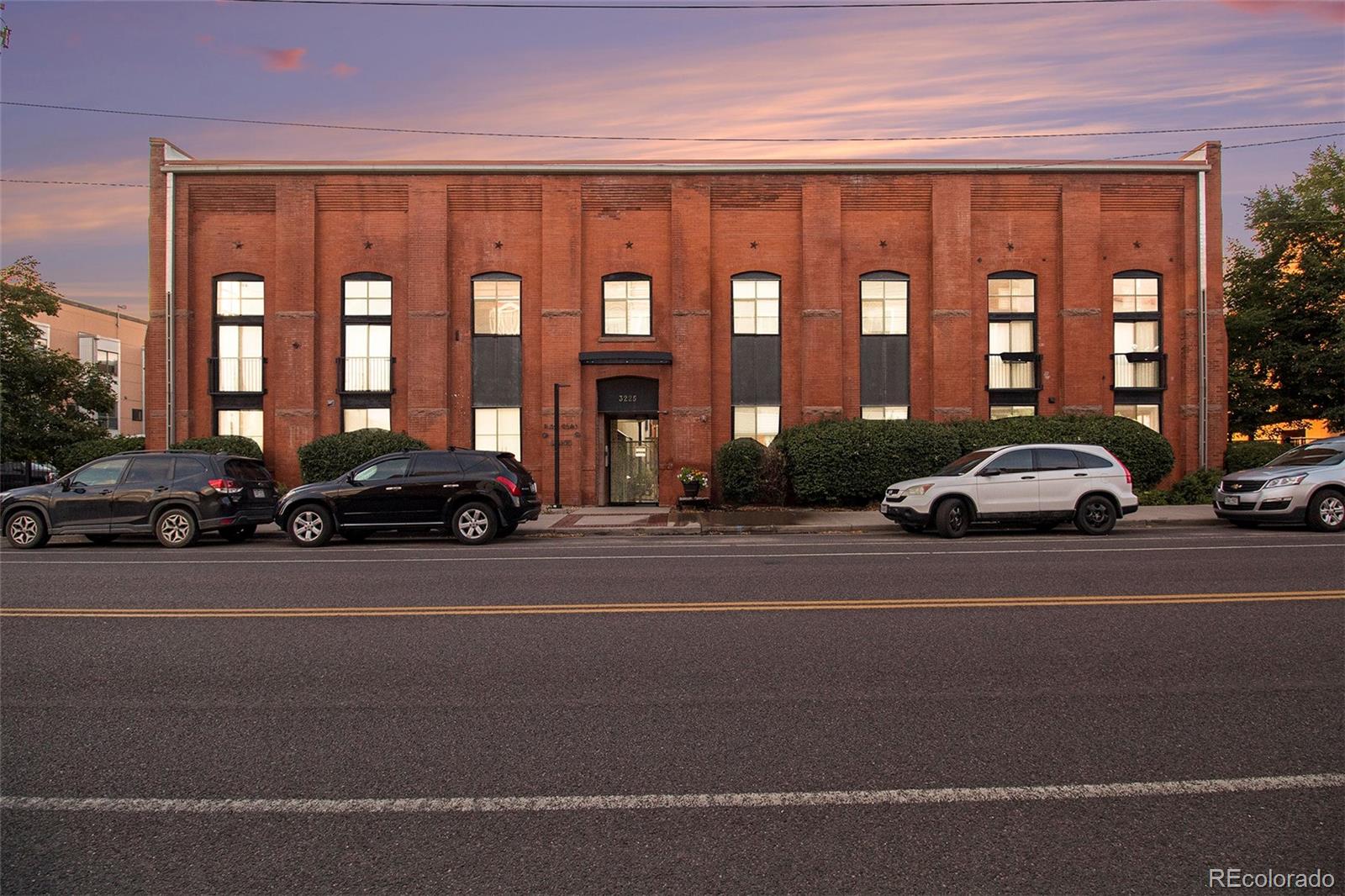 3225 Blake Street, Unit 24 Denver, CO 80205 - Photo 3 of 25 a city street lined with cars parked in front of a building
