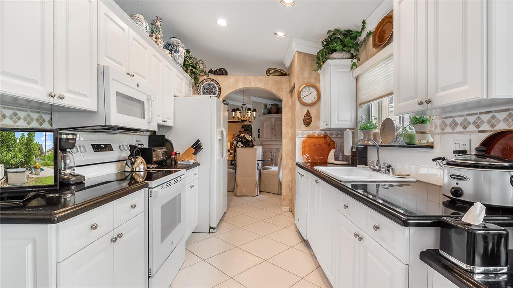 7844 Travelers Tree Drive Boca Raton, FL 33433 - Photo 12 of 40 a kitchen with stainless steel appliances granite countertop a sink and cabinets