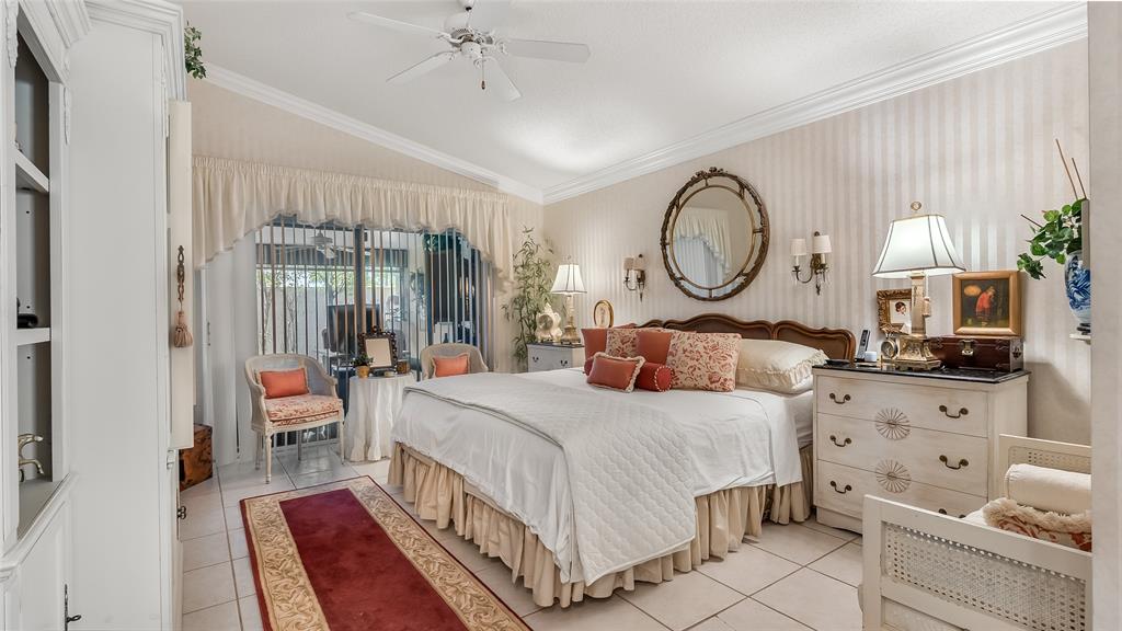 7844 Travelers Tree Drive Boca Raton, FL 33433 - Photo 15 of 40 a bedroom with bed and a chandelier