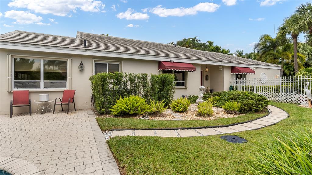 7844 Travelers Tree Drive Boca Raton, FL 33433 - Photo 32 of 40 a front view of a house with a yard and potted plants