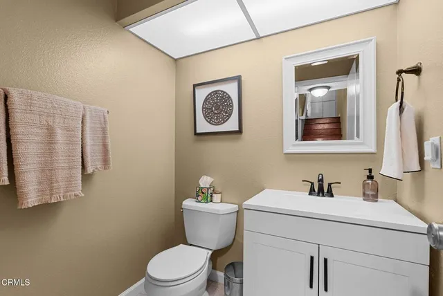 a bathroom with a toilet sink vanity and mirror