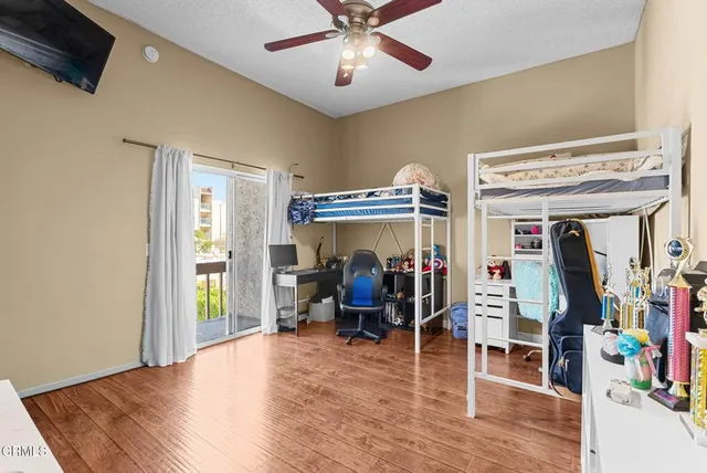 a view of a room with wooden floor and a ceiling fan